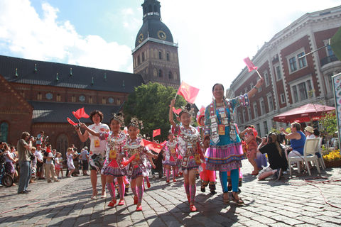 Chinesischer Chor mit ihren Fahnen bei der Parade durch die Altstadt von Riga
