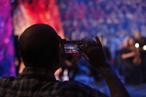 Choir on stage shown on mobile phone screen © Studi43